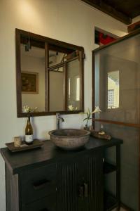 a bathroom with a stone sink and a mirror at Kyara Arthouse Villa in Thanh Ðông (1) +85 photos