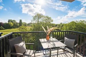 a patio with a table and chairs on a balcony at Überwasser Hotel in Cuxhaven