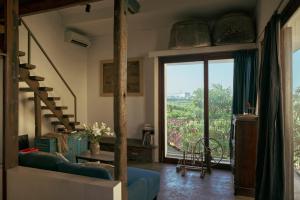 a living room with a large window and a blue couch at Kyara Arthouse Villa in Thanh Ðông (1)