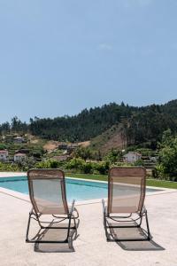 two chairs sitting next to a swimming pool at Real Villa I by Mycelia 