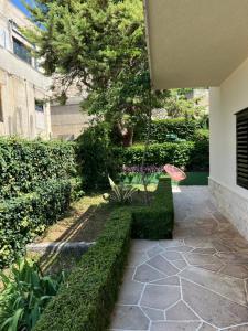 a swing in a garden with a tree and bushes at Villa Marie in Baška Voda +38 photos