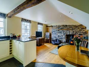 a kitchen and living room with a stone fireplace at 1 Bed in Hawkshead Village LLH18 in Hawkshead