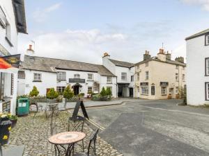 a group of buildings with tables and chairs in the street at 1 Bed in Hawkshead Village LLH18 in Hawkshead
