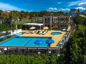 an overhead view of a pool with chairs and umbrellas at Florianópolis Costão das Gaivotas Apto estilo Resort, pé na areia in Florianópolis