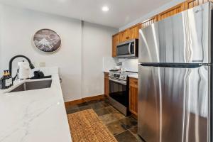 eine Küche mit einem Kühlschrank aus Edelstahl und einer Spüle in der Unterkunft Central Breck Stay Shared Hot Tub plus Ski Access in Breckenridge + 12 Fotos