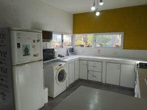 una cucina con frigorifero, lavatrice e asciugatrice di Casa con Jardín, Piscina y Vistas Increíbles en Potrero de los Funes a Potrero de los Funes