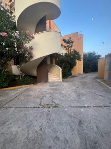 un edificio con una escalera de caracol en su lateral en Nura's - Casa Flor Seaside, en Alghero
