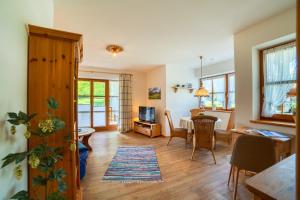 a living room with a table and a dining room at Ferienwohnung Unternberg inkl. Chiemgaukarte in Ruhpolding