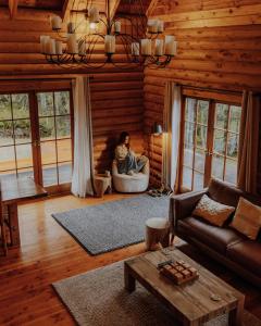 a woman sitting in a chair in a living room at Lyford Luxury Escape - ML21963 in Mt Lyford