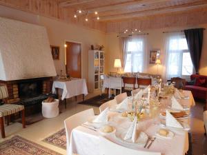 a dining room with a long table and a fireplace at Lossiranta Lodge in Savonlinna +58 photos