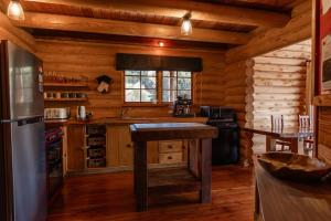 a kitchen in a log cabin with a table in it at Lyford Luxury Escape - ML21963 in Mt Lyford