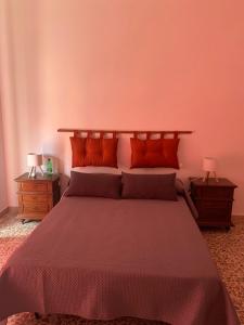a bedroom with a large bed with orange pillows at A casa di paola in Naples