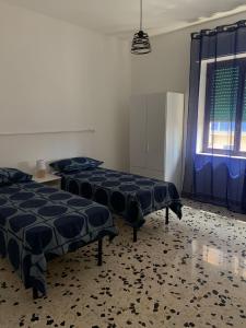 a room with three beds and a window at A casa di paola in Naples