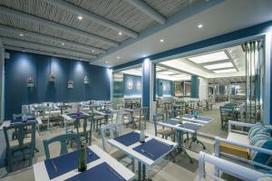 a rendering of a restaurant with blue tables and chairs at Eleni Beach Apartment in Stalís