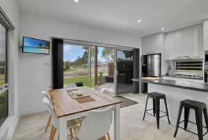 a kitchen and dining room with a table and chairs at Secret Sanctuary On Seagrass Luxury Coastal Retreat in Jervis Bay in Vincentia