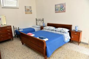 a bedroom with two beds with blue sheets at Casetta Virginia in Ischia