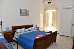 a bedroom with a bed with a blue comforter at Casetta Virginia in Ischia