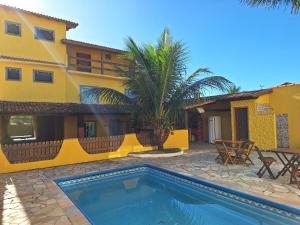 a house with a swimming pool in front of a building at Casarão Familiar Eixo Cabo Frio Buzios com piscinão in Cabo Frio