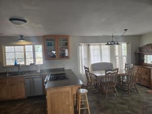 a kitchen and dining room with a table and chairs at Wildland Gardens Farm House w Private Hot tub in Joseph +12 photos