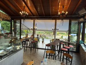 a restaurant with a bar with chairs and tables at Fanis Rooms in Kokkino Nero