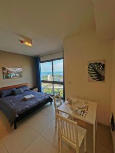 1 dormitorio con cama, mesa, cama y ventana en Unixx Sea view, en Pattaya South
