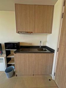 Una pequeña cocina con fregadero y microondas. en Unixx Sea view, en Pattaya South 5 fotos más