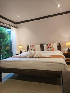 a bedroom with a large bed with a large window at Bang Po Hut in Ban Bang Po