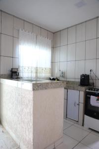 a kitchen with a counter top in a room at Casa completa com 2 quartos e enxoval 35C in Sete Lagoas