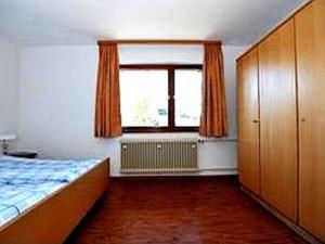 - une chambre avec un lit et une grande fenêtre dans l'établissement Schlesierhaus, à Dachsberg im Schwarzwald