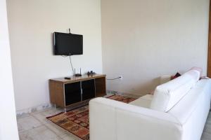 a living room with two white couches and a tv at Casa Privativa em Sete Lagoas 35C in Sete Lagoas