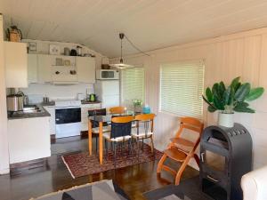 una cucina con un tavolo e sedie in una stanza di Cabin at Hestsjøen Badeplass a Trondheim Altre 5 foto
