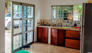 a kitchen with a sink and a counter with windows at Cabaña la isla in Coveñas