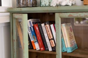 a book shelf with books on it at The Reads Freycinet - Water Front Property in Coles Bay