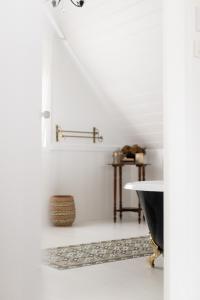a white bathroom with a tub and a rug at The Reads Freycinet - Water Front Property in Coles Bay +51 photos