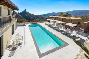 a swimming pool on the side of a building with chairs at Villa Zagara in Savoca