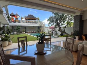 a dining room with a glass table and chairs at Oshan Villas Bali in Canggu