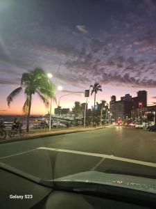 Una calle con una palmera y una persona en bicicleta. en Quarto e Sala de Alto Padrão, en Salvador