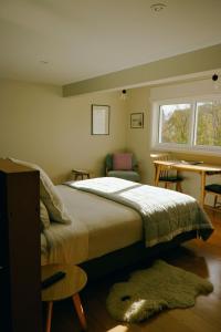 a bedroom with a bed and a desk and a window at Kowhai Studio -private opposite golf course in central Wanaka in Wanaka