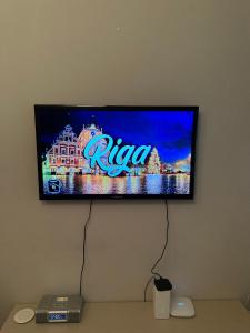 a flat screen tv hanging on a wall at Cozy Apartment- Self Check- In in Riga