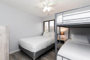 a bedroom with two bunk beds and a ceiling fan at Modern Condo Central Huron Boat Basin Area in Huron