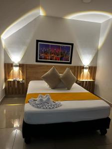 Un dormitorio con una cama con un cuadro en la pared. en Sixth House Suite, en Cali