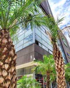 two palm trees in front of a building at Apartamento Loft con vista unica in Itagüí