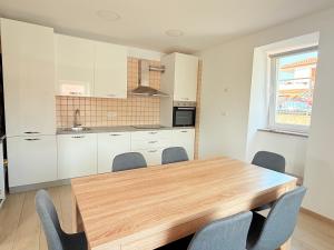 a kitchen with a wooden table and chairs at Apartma Zala in Šmarje