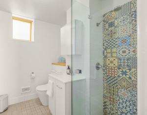 a bathroom with a shower with a toilet and a sink at Central Fremantle Lifestyle walk to markets, cafe, bars in Fremantle +32 photos