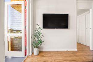a living room with a flat screen tv on a wall at Central Fremantle Lifestyle walk to markets, cafe, bars in Fremantle
