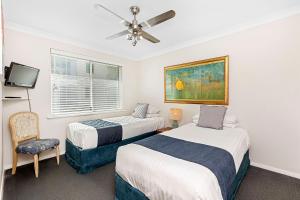 a bedroom with two beds and a ceiling fan at Seashells Scarborough in Perth +40 photos