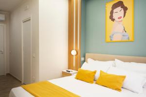a bedroom with a bed with yellow pillows and a painting at N'Ador Rooms in Naples +39 photos