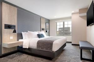 a hotel room with a large bed and a chair at ClubHouse Hotel & Suites Rapid City in Rapid City