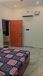 a bedroom with a bed and a wooden door at Atharv homestay Near Hanuman Tempal And Saryugath in Ayodhya