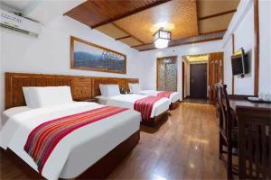 Posteľ alebo postele v izbe v ubytovaní Zhangjiajie Wulingju Hotel